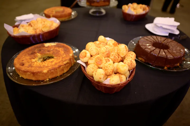 Mesa de café com pão de queijo e bolos